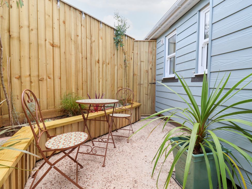 A garden area with a table and chairs at Still Waters in Brixham
