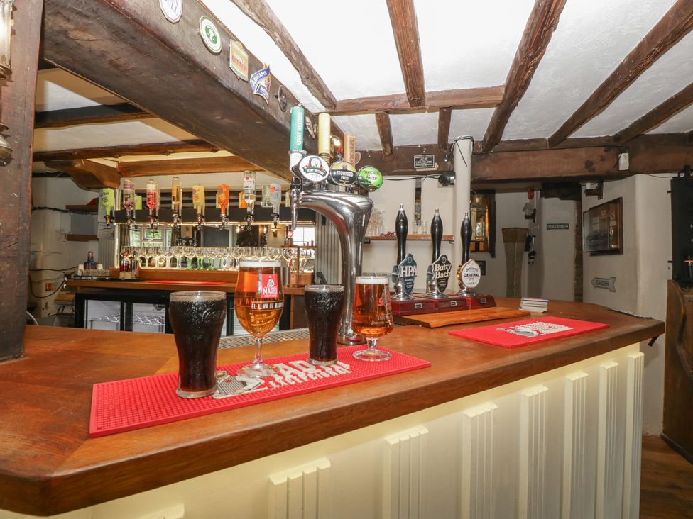 A bar counter with beer taps and drinks at Penny Farthing Inn Aston Crews near Ross-On-Wye