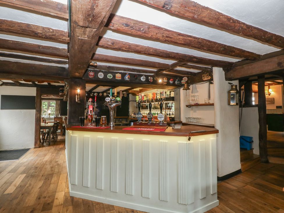 A bar with beer taps and liquor bottles at Penny Farthing Inn Aston Crews near Ross-On-Wye