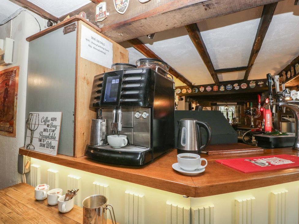 A coffee machine with cups and a jug at Penny Farthing Inn Aston Crews near Ross-On-Wye