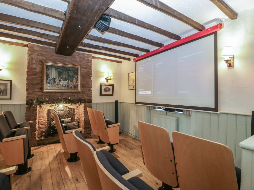 A home theater with a projector and seating at Penny Farthing Inn Aston Crews near Ross-On-Wye