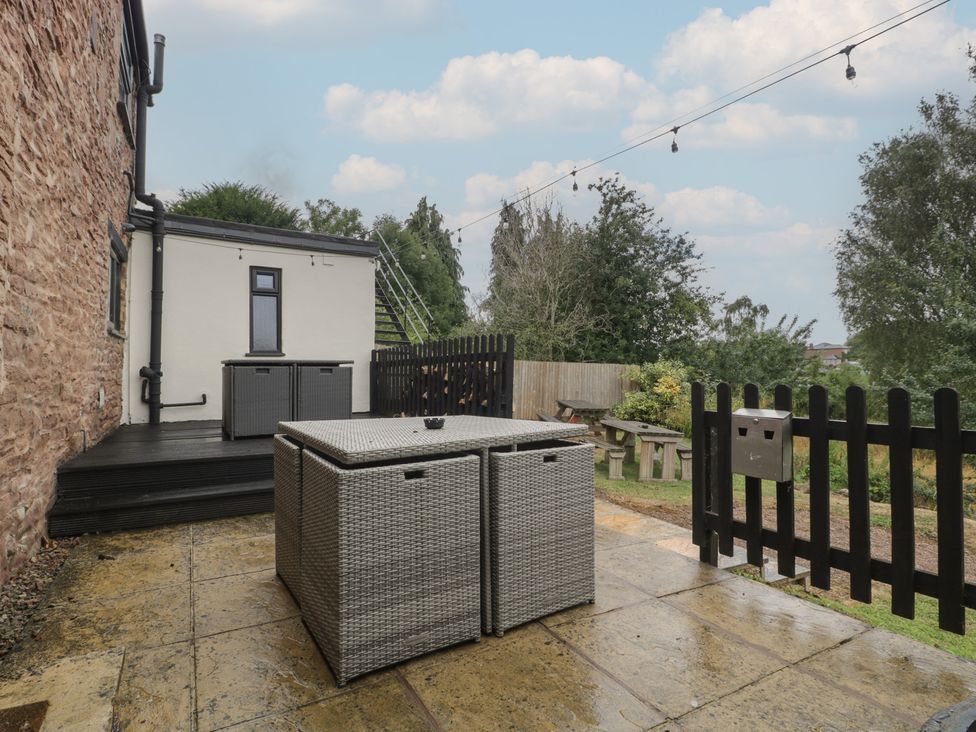 A garden with a patio table and storage boxes at Penny Farthing Inn Aston Crews near Ross-On-Wye