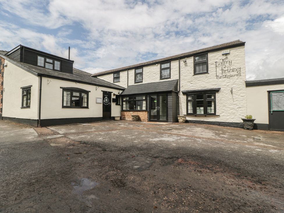 An outdoor view of the Penny Farthing Inn restaurant with entrances and parking area in Aston Crews near Ross-On-Wye