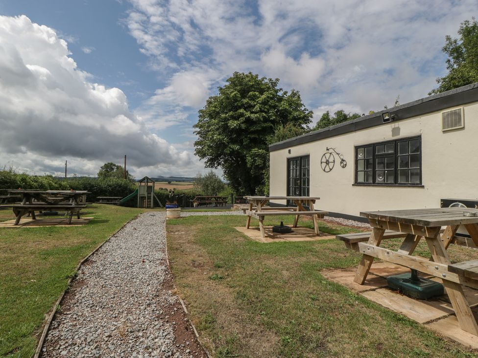 An outdoor area with picnic tables and playground equipment at Penny Farthing Inn Aston Crews near Ross-On-Wye