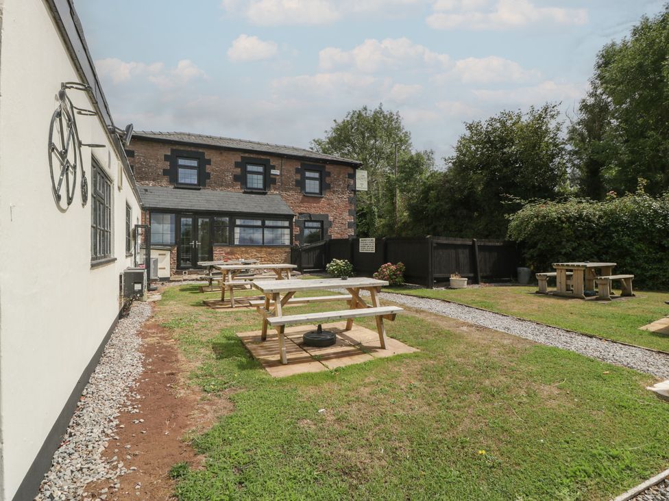 An outdoor area with tables and benches at Penny Farthing Inn Aston Crews near Ross-On-Wye