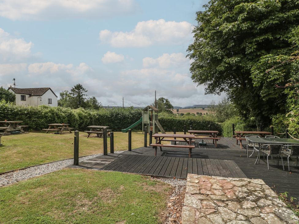 An outdoor area with tables and benches at Penny Farthing Inn Aston Crews near Ross-On-Wye