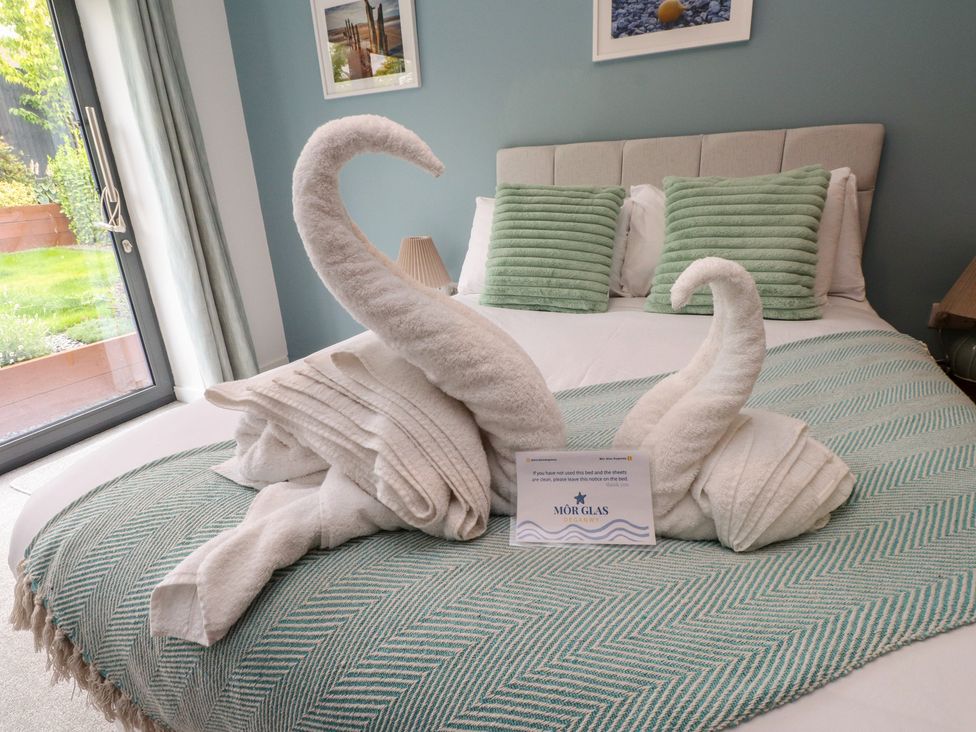 A bedroom with swan-shaped towels on the bed at 70 Deganwy Road in Deganwy