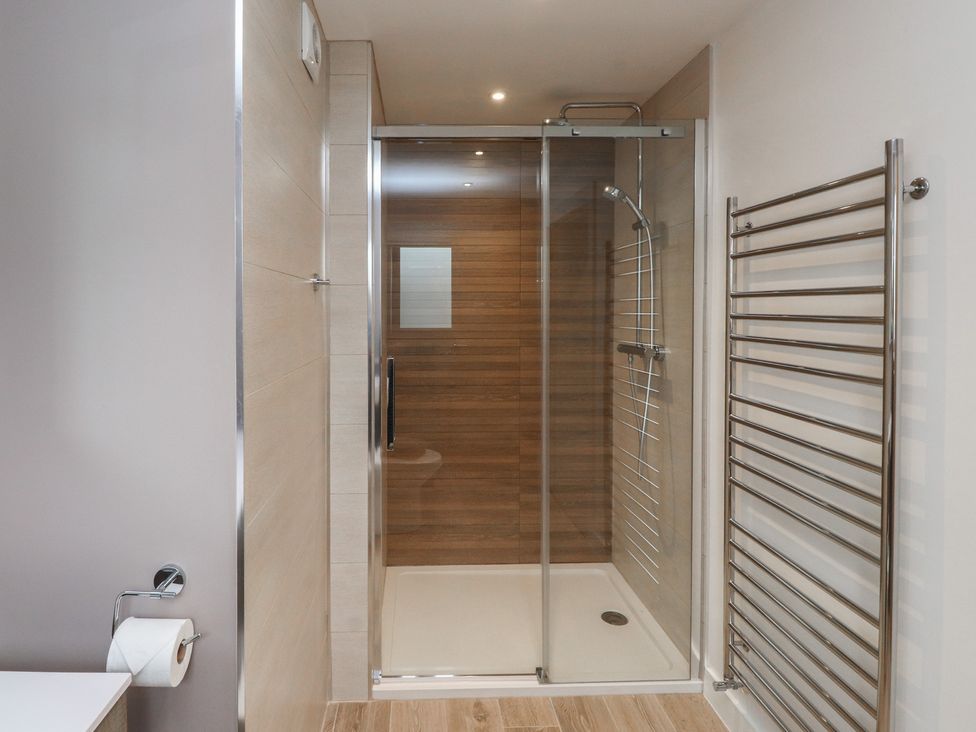 A bathroom with a shower and towel radiator at 70 Deganwy Road, Deganwy
