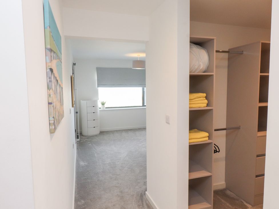A bedroom with a closet and light fixture at Môr Glas Deganwy