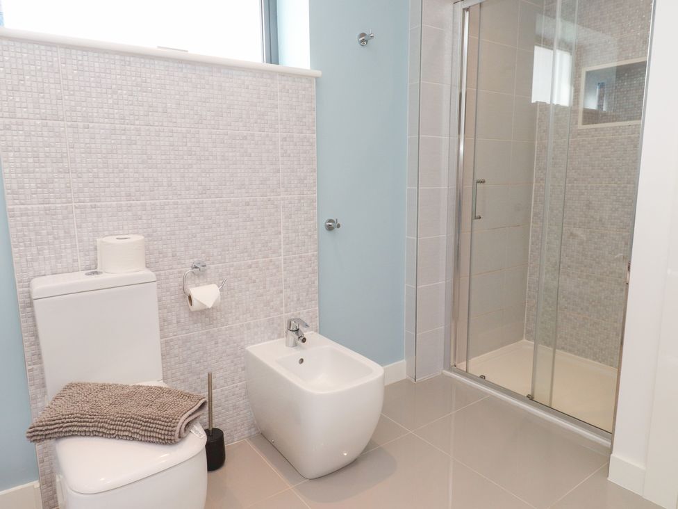 A bathroom with a toilet, bidet, and shower at Môr Glas, Deganwy