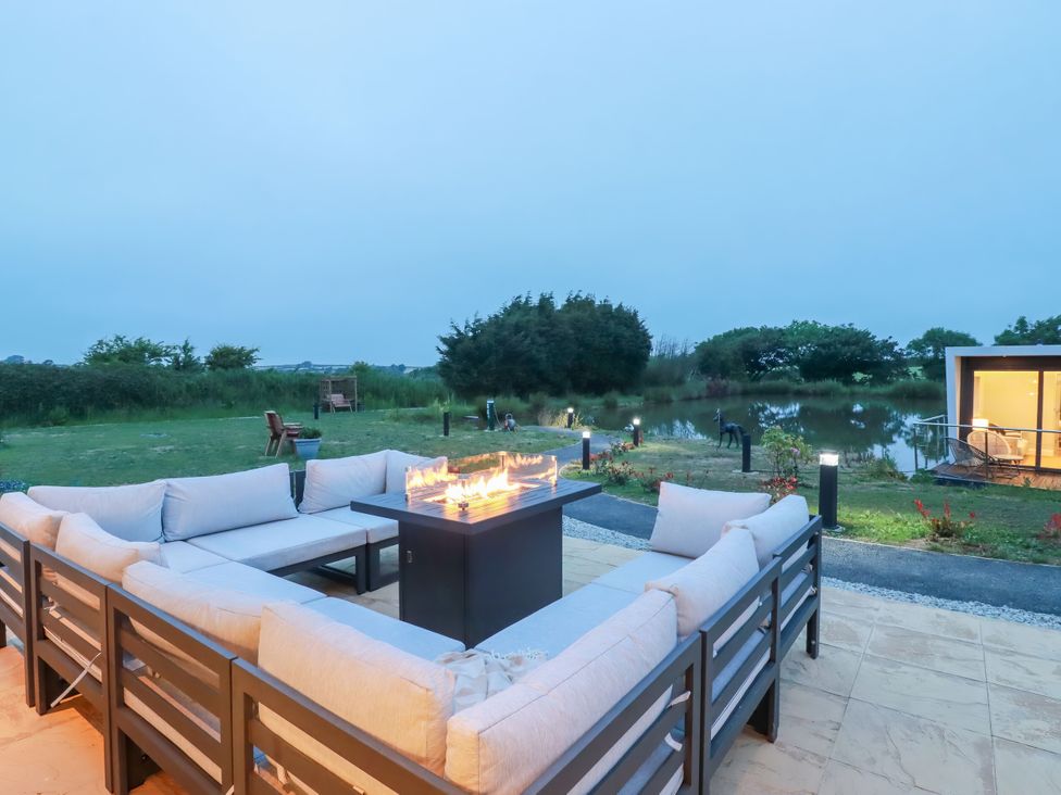 An outdoor seating area with a fire pit at The Lake Boat exclusive retreat Black Cross near St Columb Major