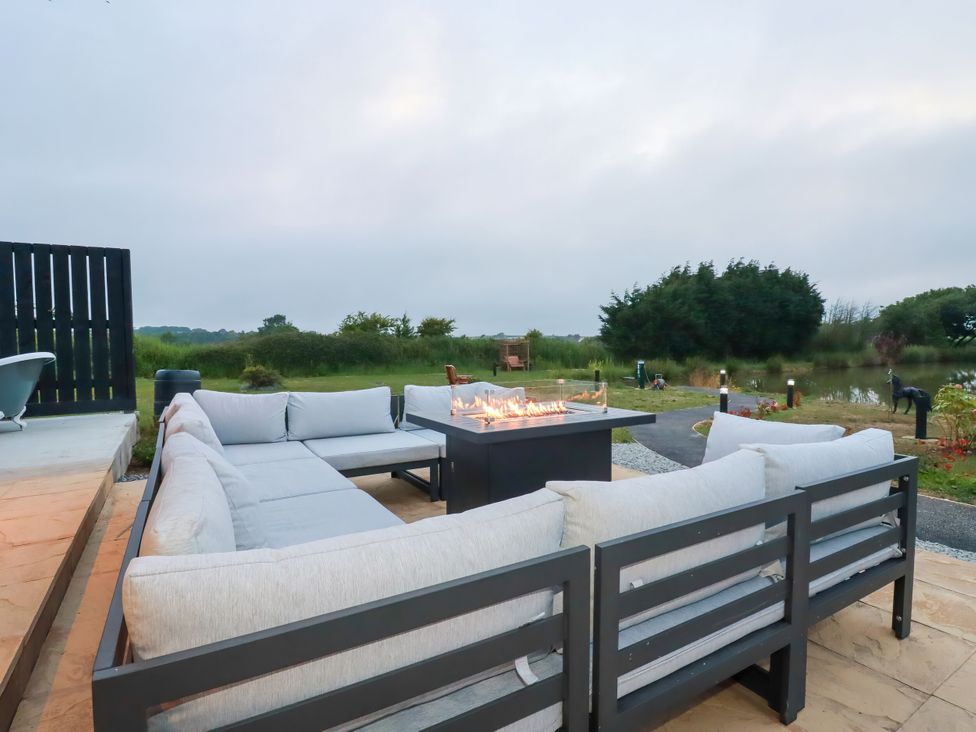 An outdoor seating area with a fire pit at The Lake Boat exclusive retreat near Black Cross