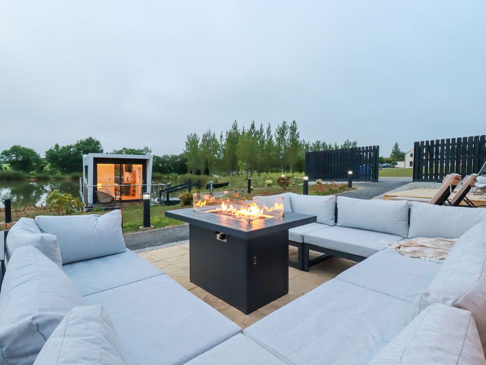 An outdoor seating area with a fire pit at The Lake Boat exclusive retreat Black Cross near St Columb Major