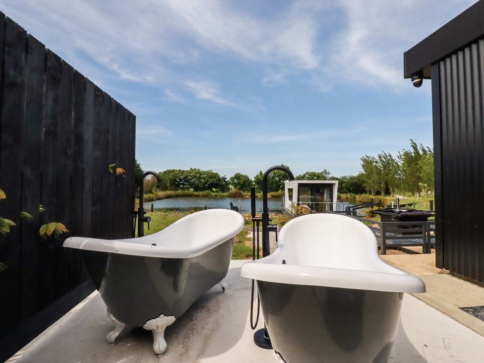 Two bathtubs near a pond at The Lake Boat exclusive retreat Black Cross near St Columb Major