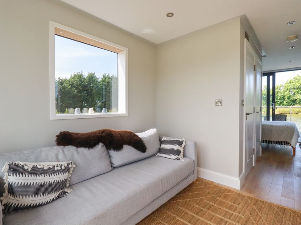 A living room with a sofa and a window at The Lake Boat exclusive retreat Black Cross near St Columb Major