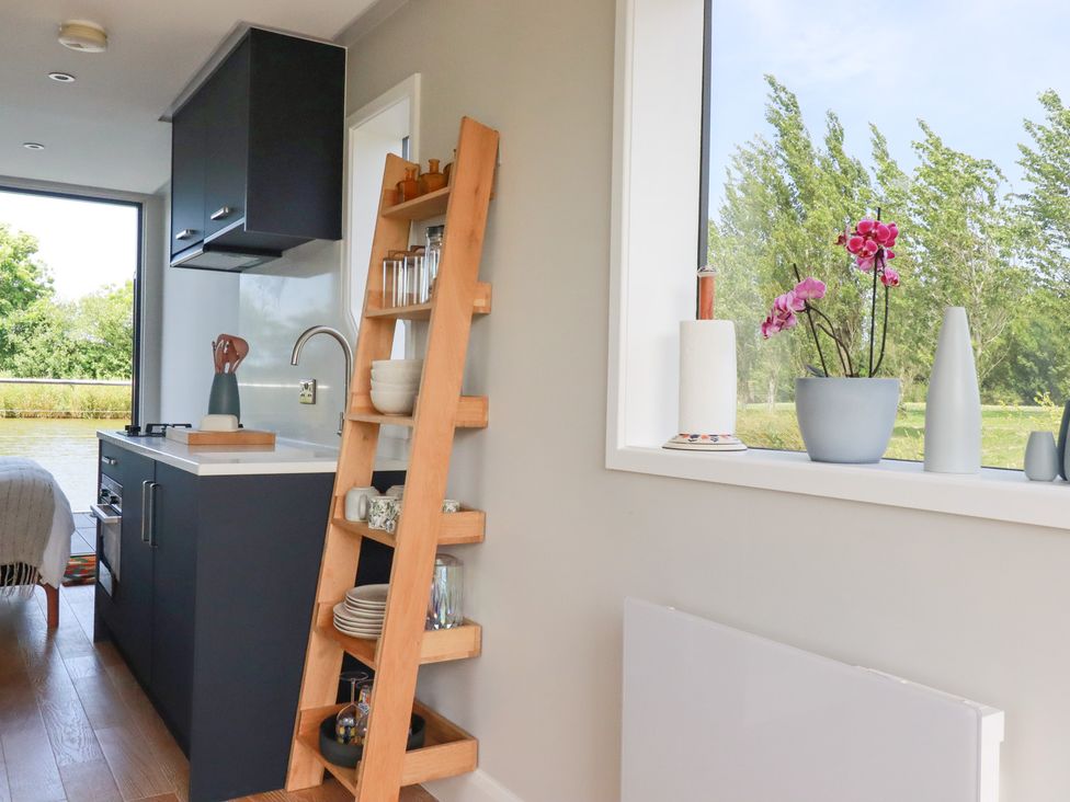 A kitchen with a window and shelving unit at The Lake Boat exclusive retreat in Black Cross near St Columb Major