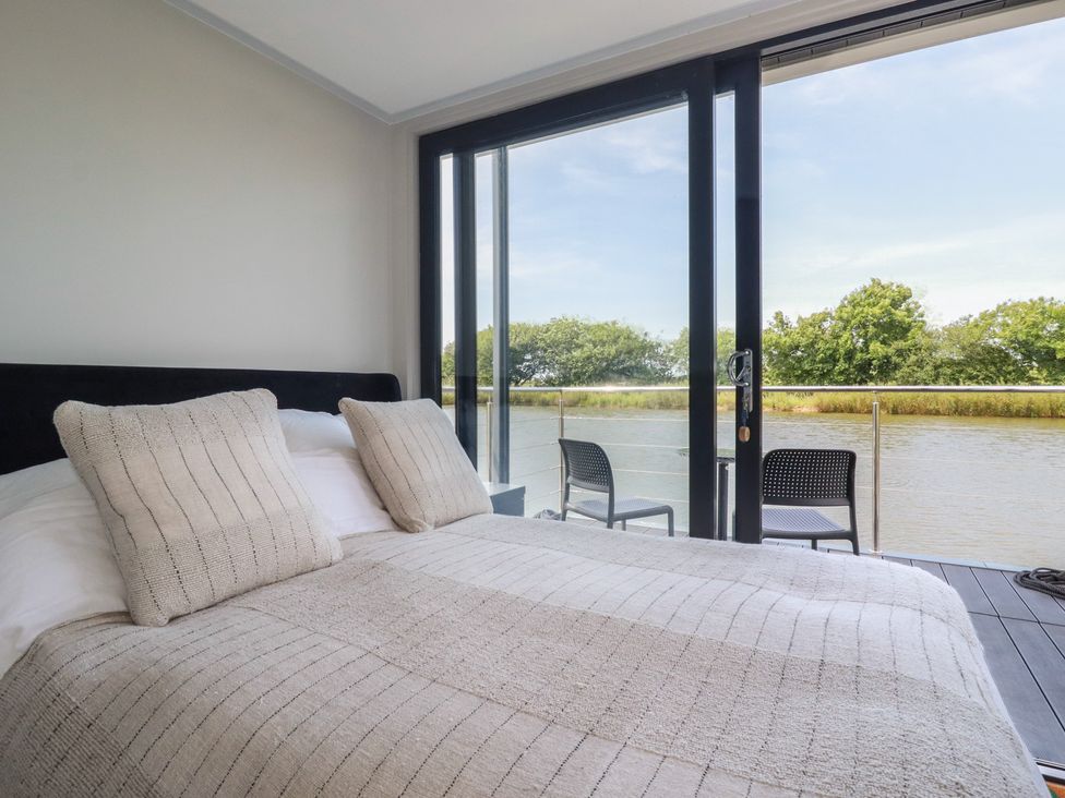 A bedroom with a bed and river view at The Lake Boat exclusive retreat Black Cross near St Columb Major