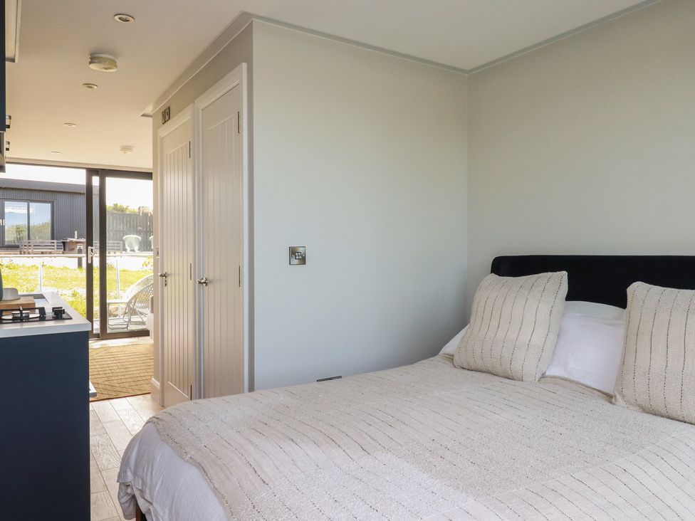 A bedroom with a bed and sliding door at The Lake Boat exclusive retreat Black Cross near St Columb Major
