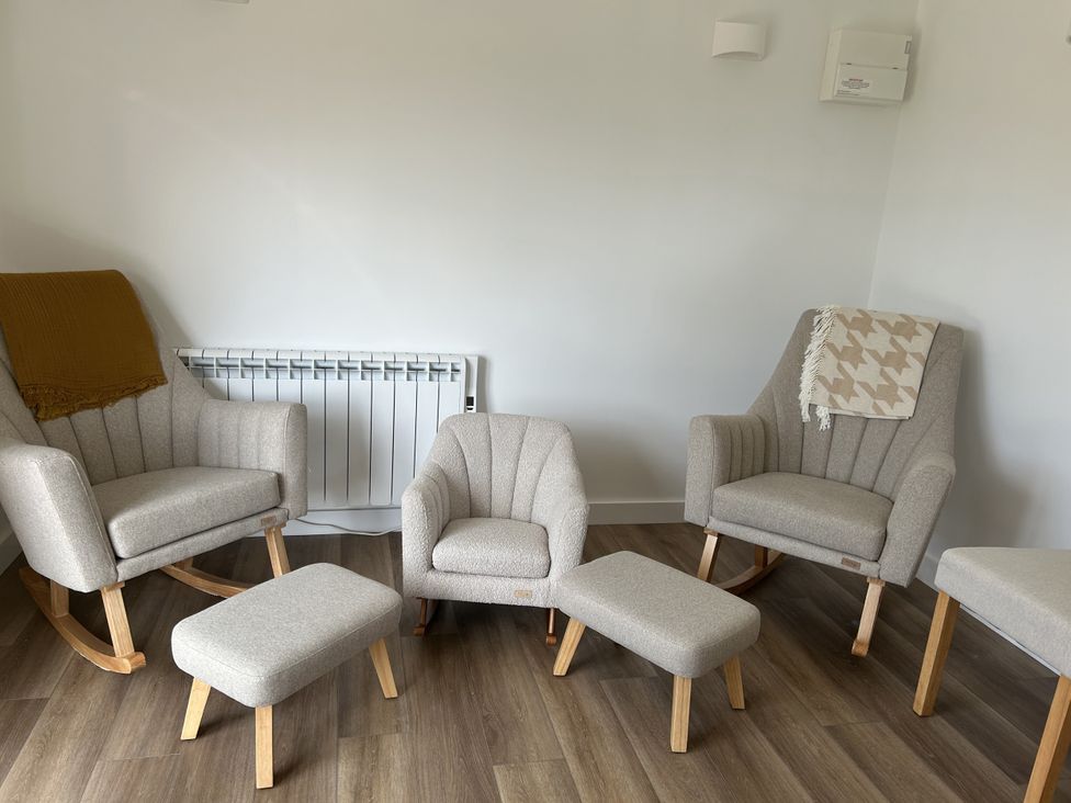 A living room with furniture including armchairs and footstools at The Lake Boat exclusive retreat Black Cross near St Columb Major