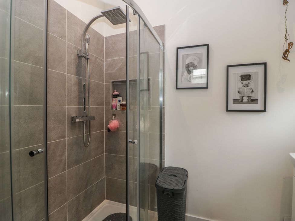 A shower with glass enclosure and framed pictures at The Annex