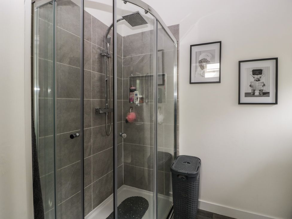 A shower with glass doors and wall art in a bathroom at The Annex