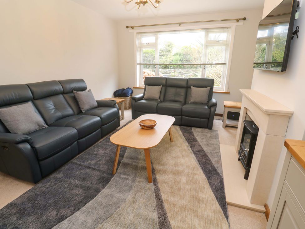 A living room with sofas and a fireplace at Byron’s Retreat in Crantock
