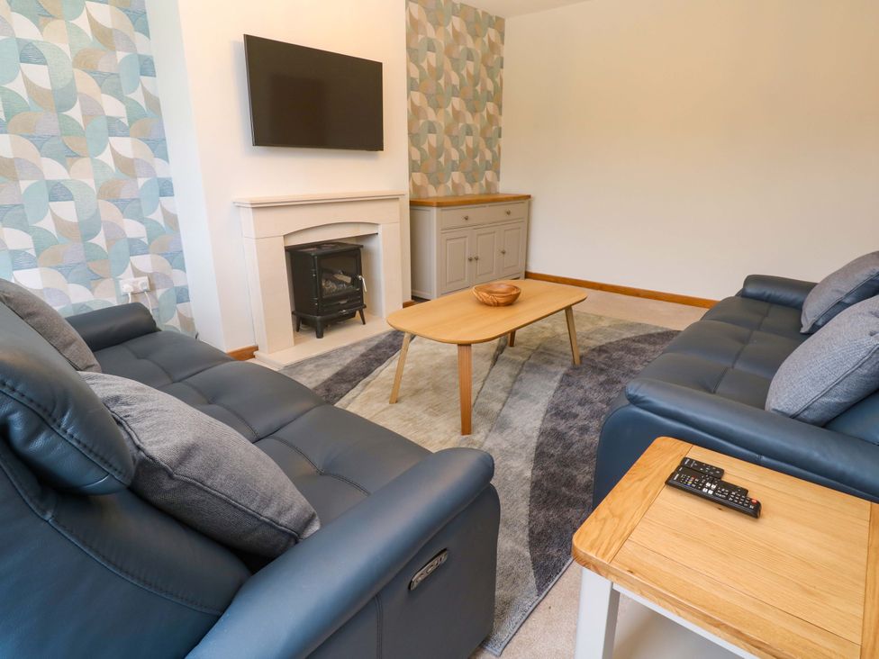 A living room with a television and sofa at Byron’s Retreat in Crantock
