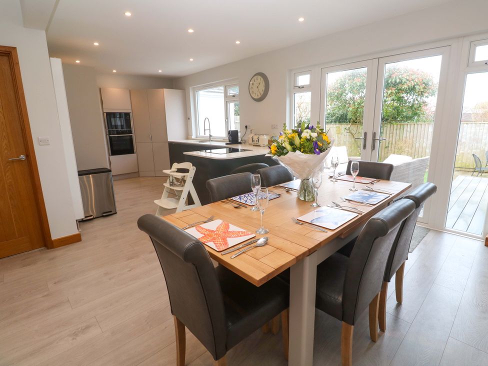 A dining room with a table and chairs at Byron’s Retreat in Crantock