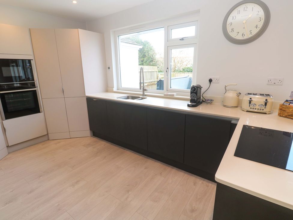 A kitchen with a sink and modern appliances at Byron’s Retreat in Crantock