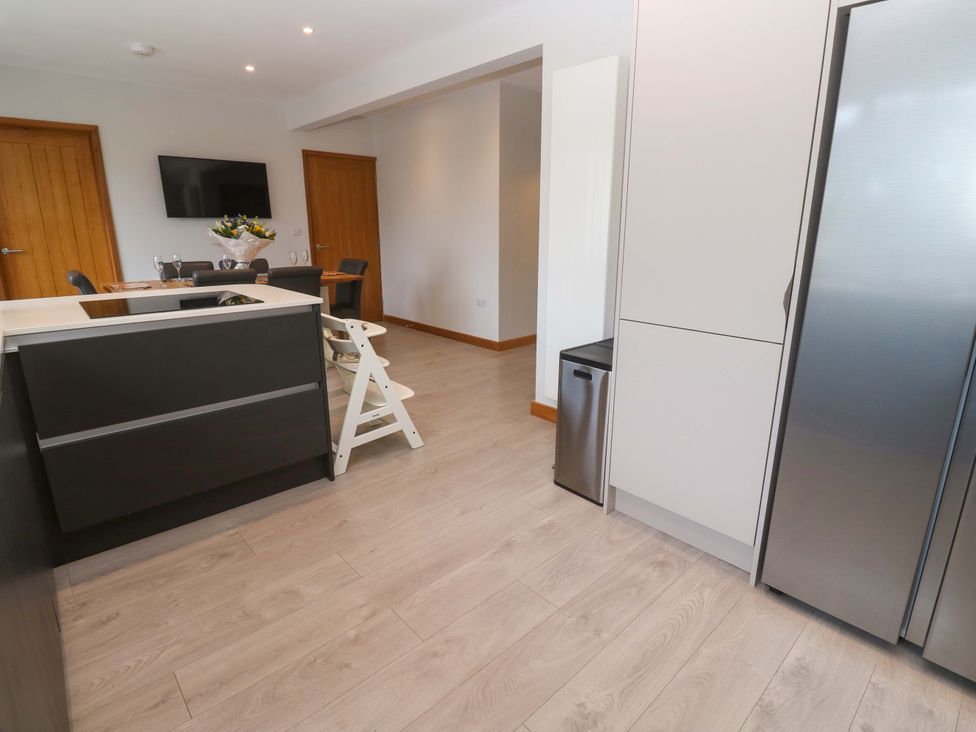 A kitchen with a dining area and modern appliances at Byron’s Retreat in Crantock