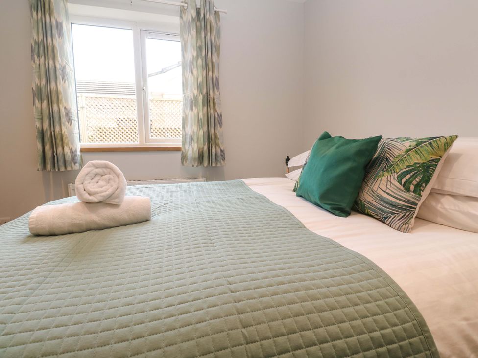 A bedroom with a bed and pillows at Byron’s Retreat in Crantock