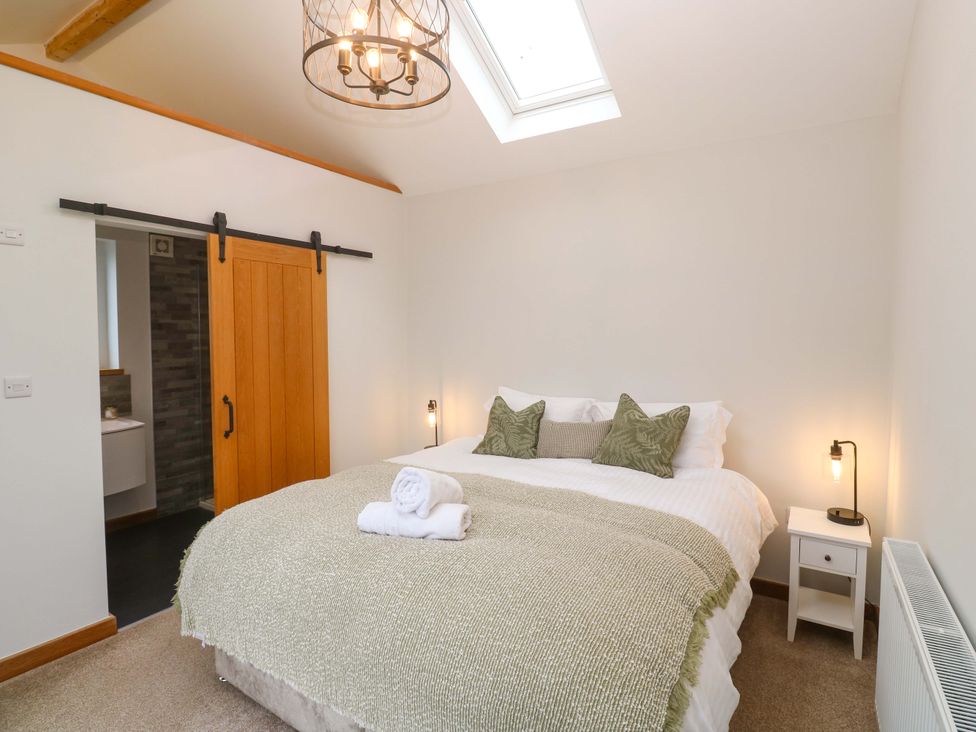 A bedroom with a bed and sliding door at Byron’s Retreat in Crantock