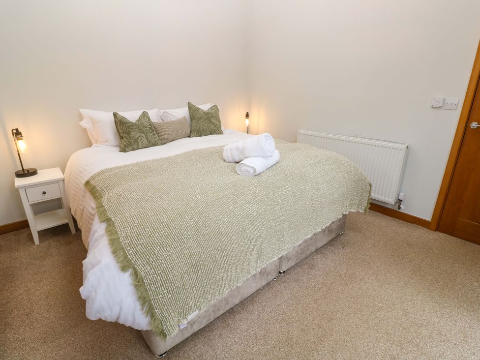 A bedroom with a bed and bedside table at Byron’s Retreat in Crantock