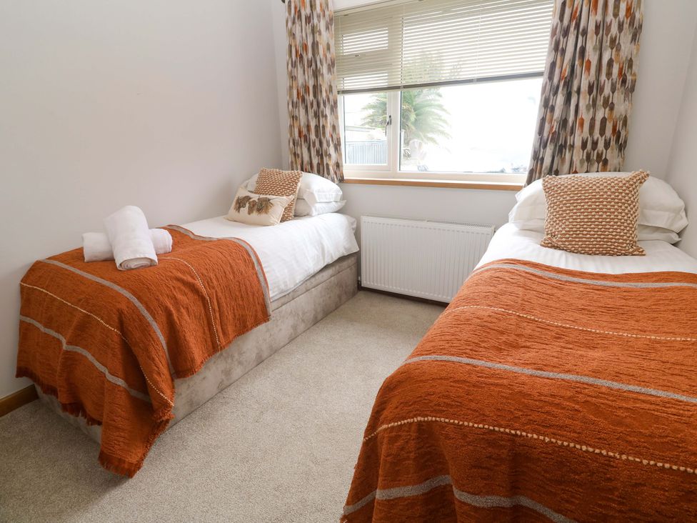 A bedroom with two beds and a window at Byron’s Retreat in Crantock
