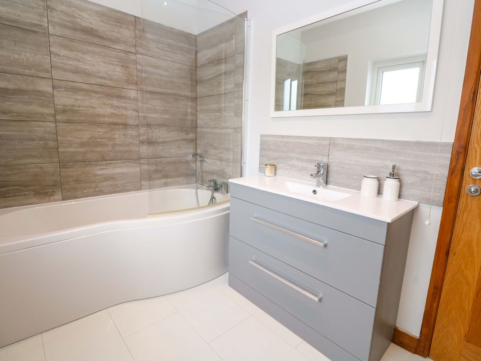 A bathroom with a bathtub and sink at Byron’s Retreat in Crantock