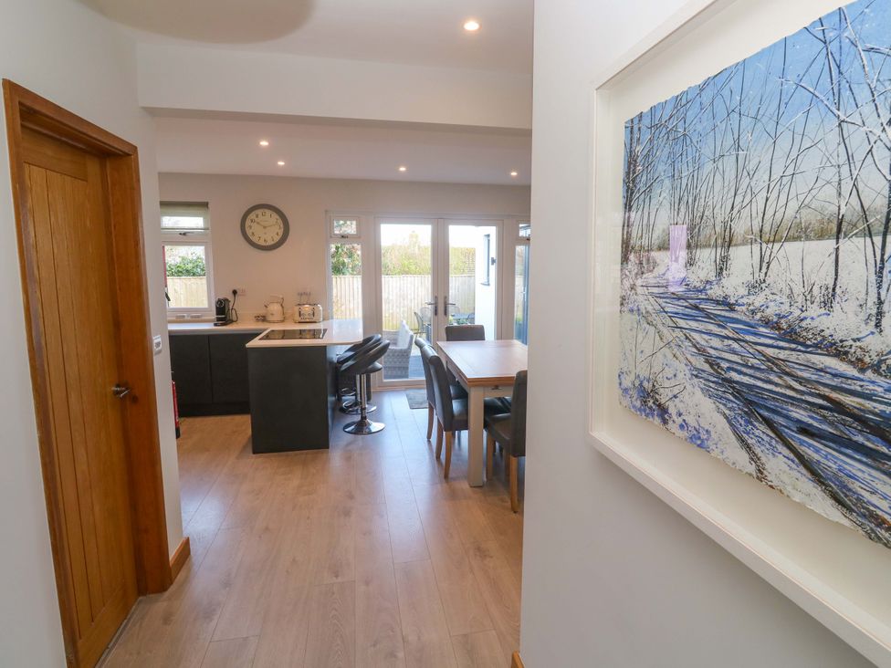 A kitchen area with a table and chairs at Byron’s Retreat in Crantock