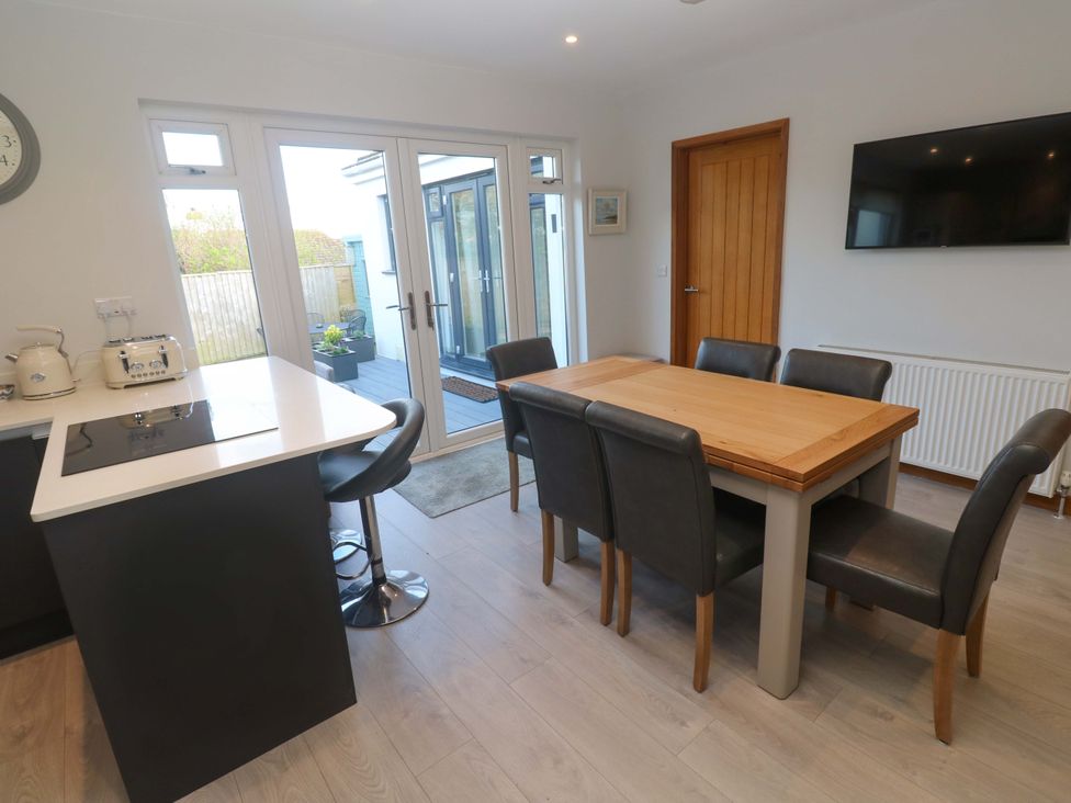 A kitchen with a dining table and chairs at Byron’s Retreat in Crantock