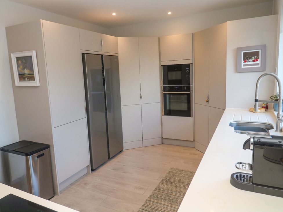 A kitchen with cabinets, refrigerator and oven at Byron’s Retreat in Crantock