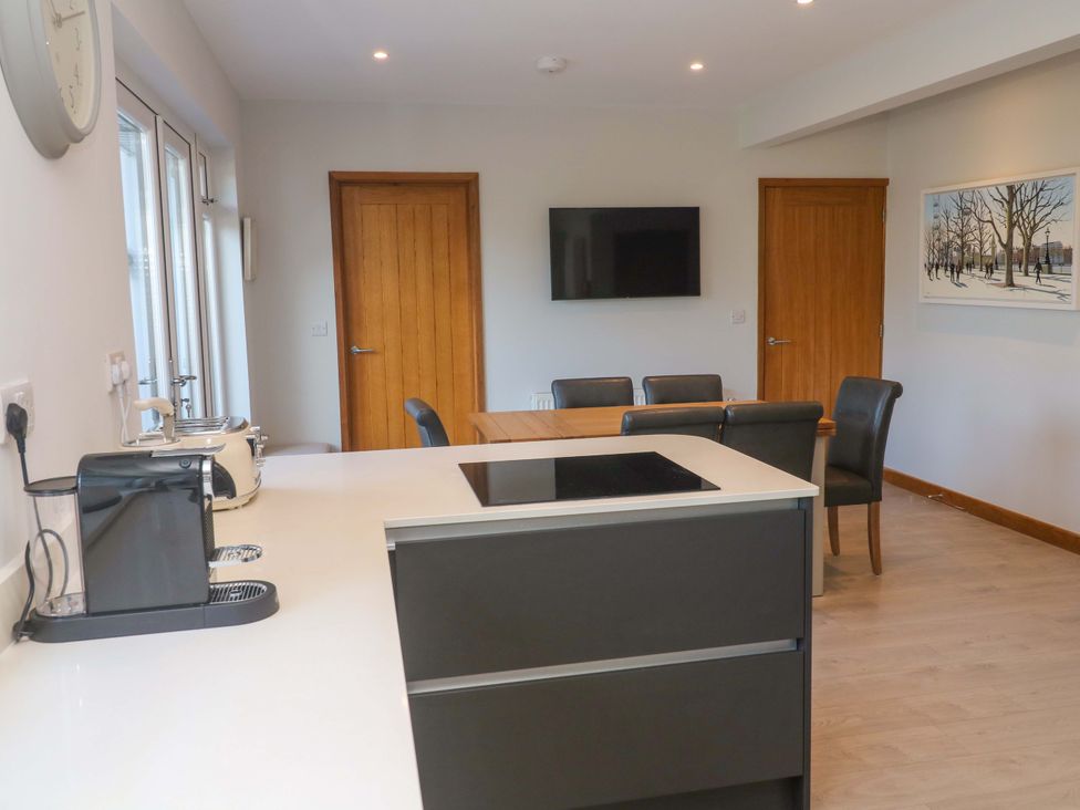 A kitchen with a table and chairs at Byron’s Retreat in Crantock