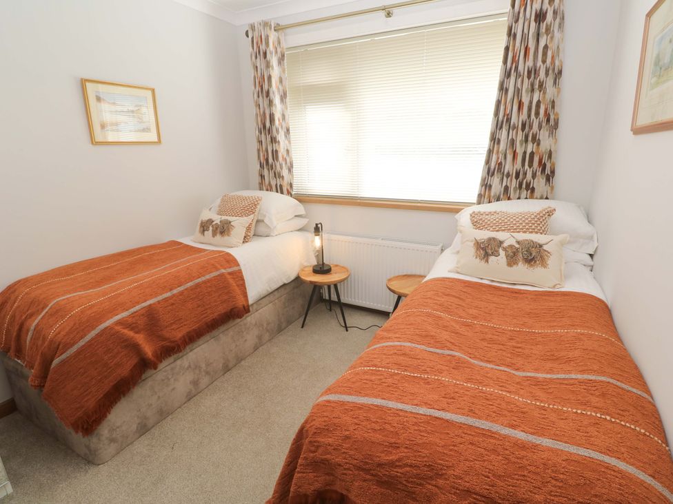 A bedroom with two single beds and a side table at Byron’s Retreat, Crantock