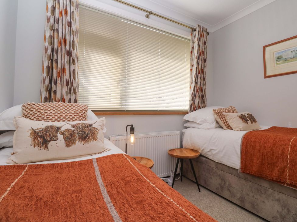 A bedroom with two beds and a window at Byron’s Retreat in Crantock