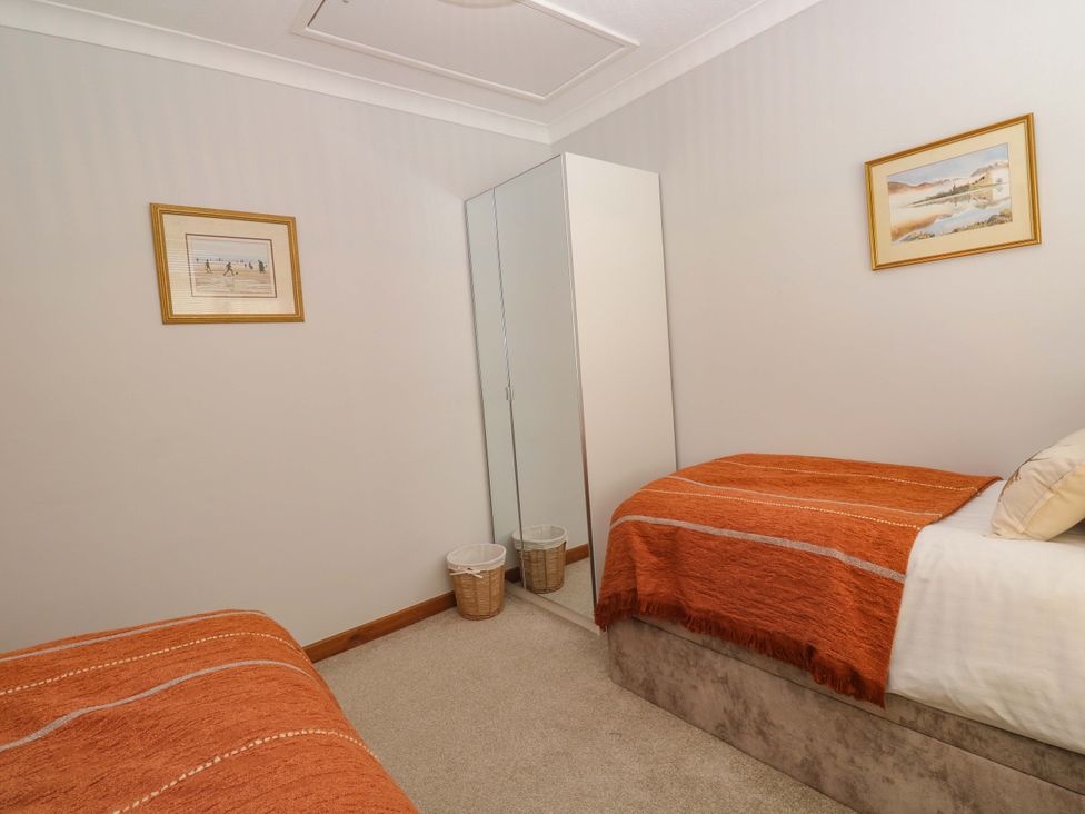 A bedroom with two beds and a mirror at Byron’s Retreat in Crantock