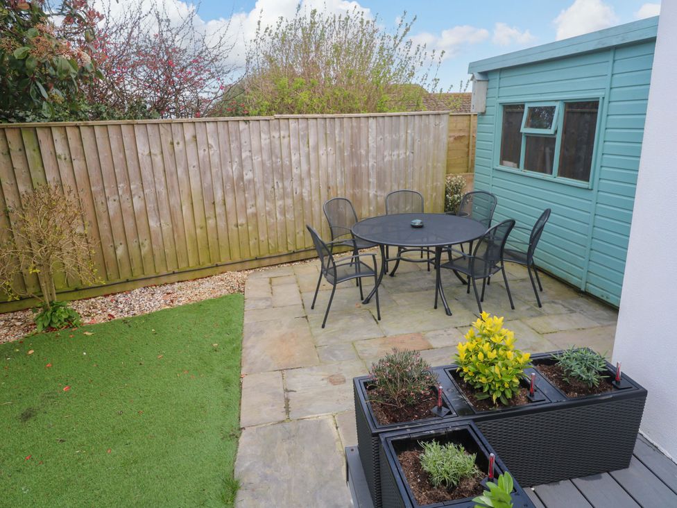 A garden with a table and chairs at Byron’s Retreat in Crantock
