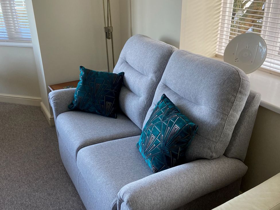 A sofa with cushions in a living room at Purbeck Vista in Swanage