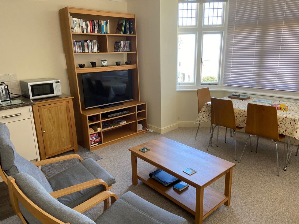 A living room with a sofa and dining table at Purbeck Vista in Swanage