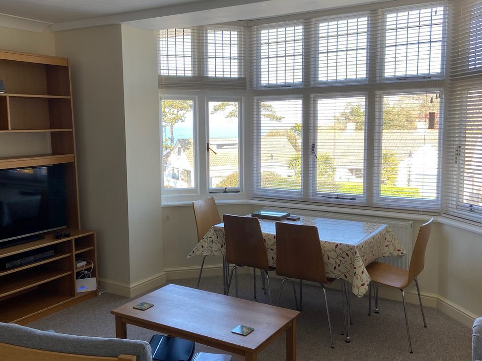 A living room with a television and dining area at Purbeck Vista in Swanage