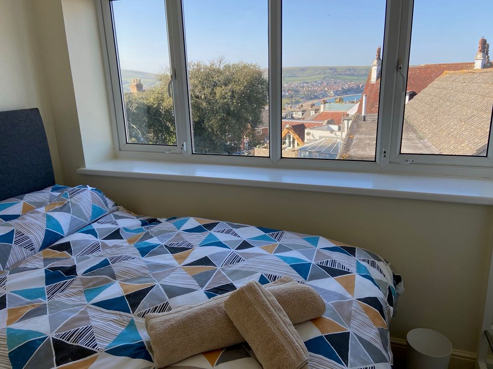 A bedroom with a bed and towels at Purbeck Vista in Swanage