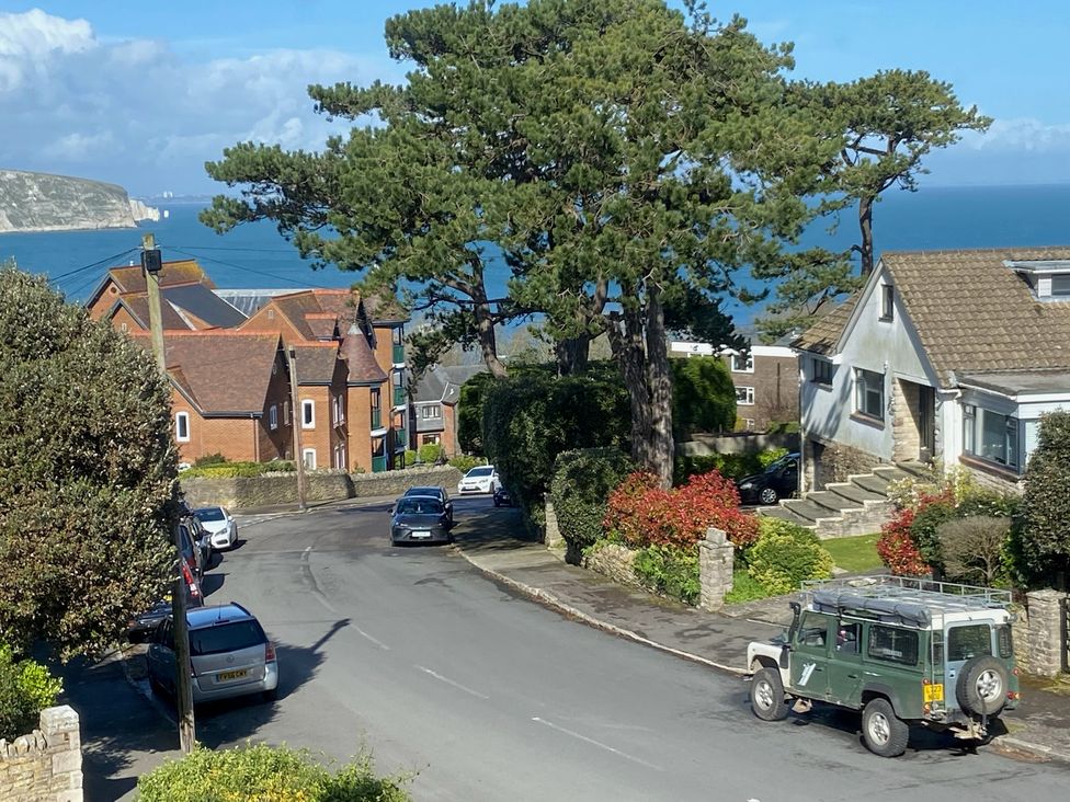 A street view with houses and vehicles near the sea at Purbeck Vista, Swanage