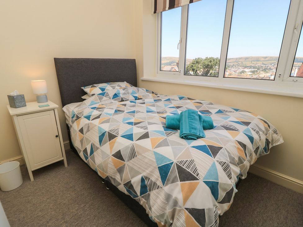 A bedroom with a bed and bedside table at Purbeck Vista in Swanage