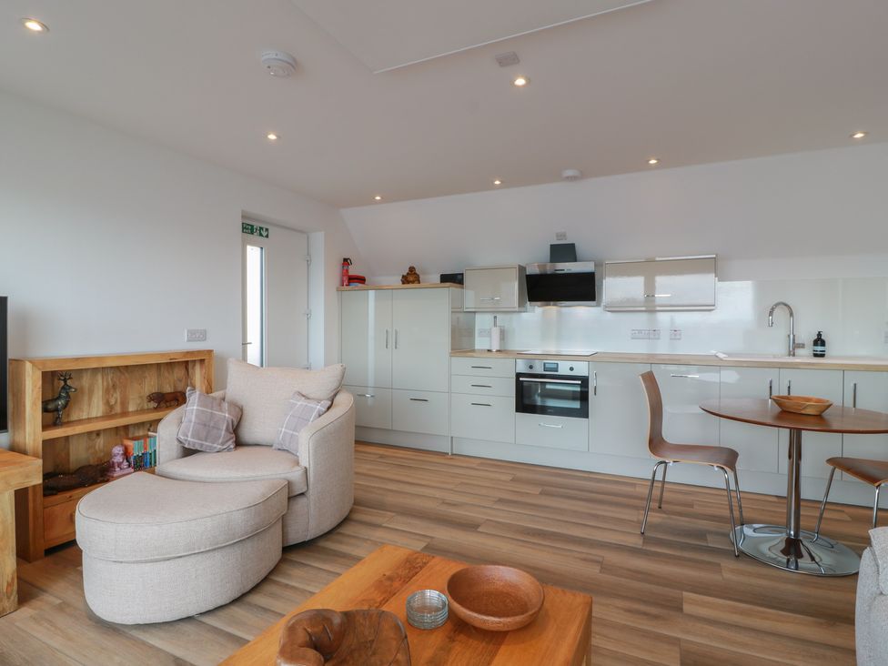 A living room with a sofa and kitchen unit at Lazy Bulldog